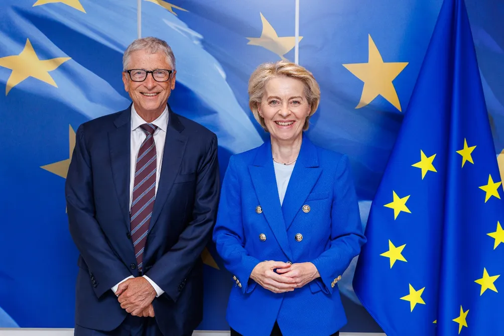 Billa Gates e un altra persona in abito formale davanti alla bamdiera dell Unione Europea